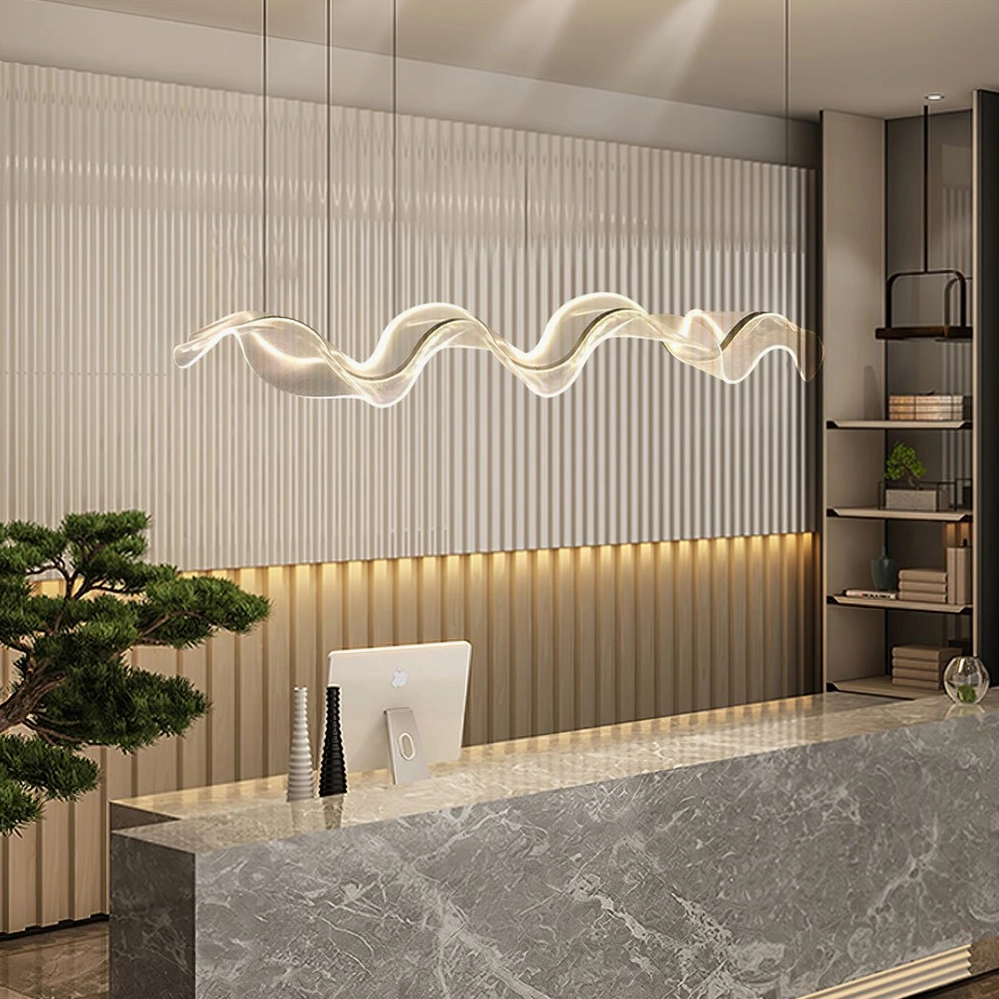 Alon Linear Chandelier installed above reception area, side view showing sculptural ribbon form and brass canopy