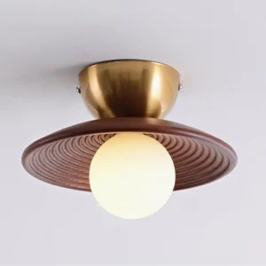 Close-up view of Alora ceiling light showing brass base, ribbed wood texture and diffused frosted bulb