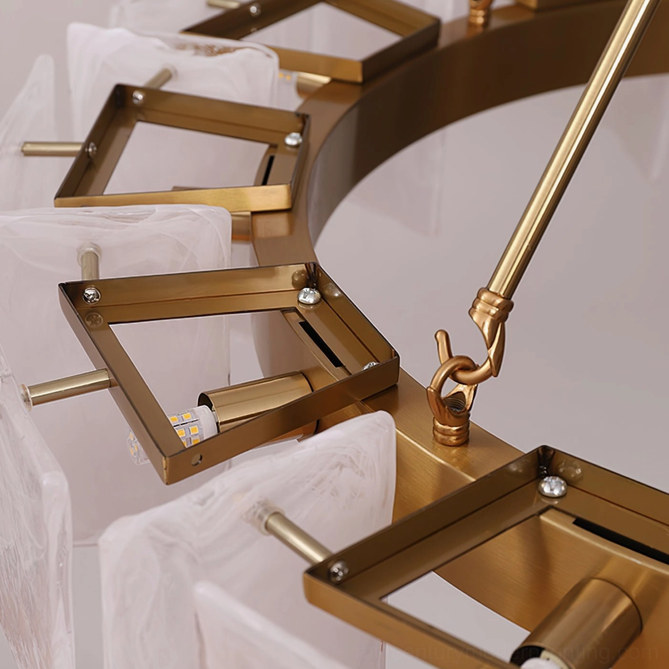 Bottom-up macro view of Alsona chandelier internal frame structure showing brass gold metal frame and adjustable bulb fixtures