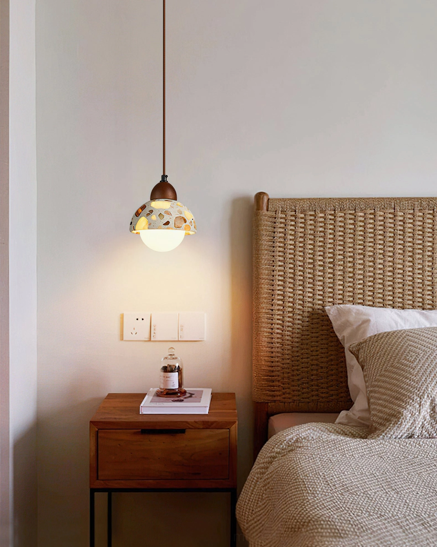 Small Alvaro pendant lamp above rattan headboard in modern bedroom setting