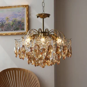 Vintage crystal chandelier in amber, three-quarter view in cozy living room with warm lighting, lit bulbs and brass hardware visible