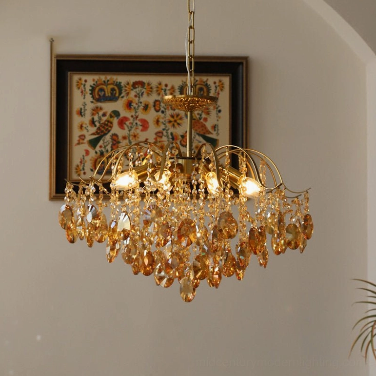 Amber crystal chandelier with gold brass frame, detailed view of polished metal arms and cut crystal teardrop pendants