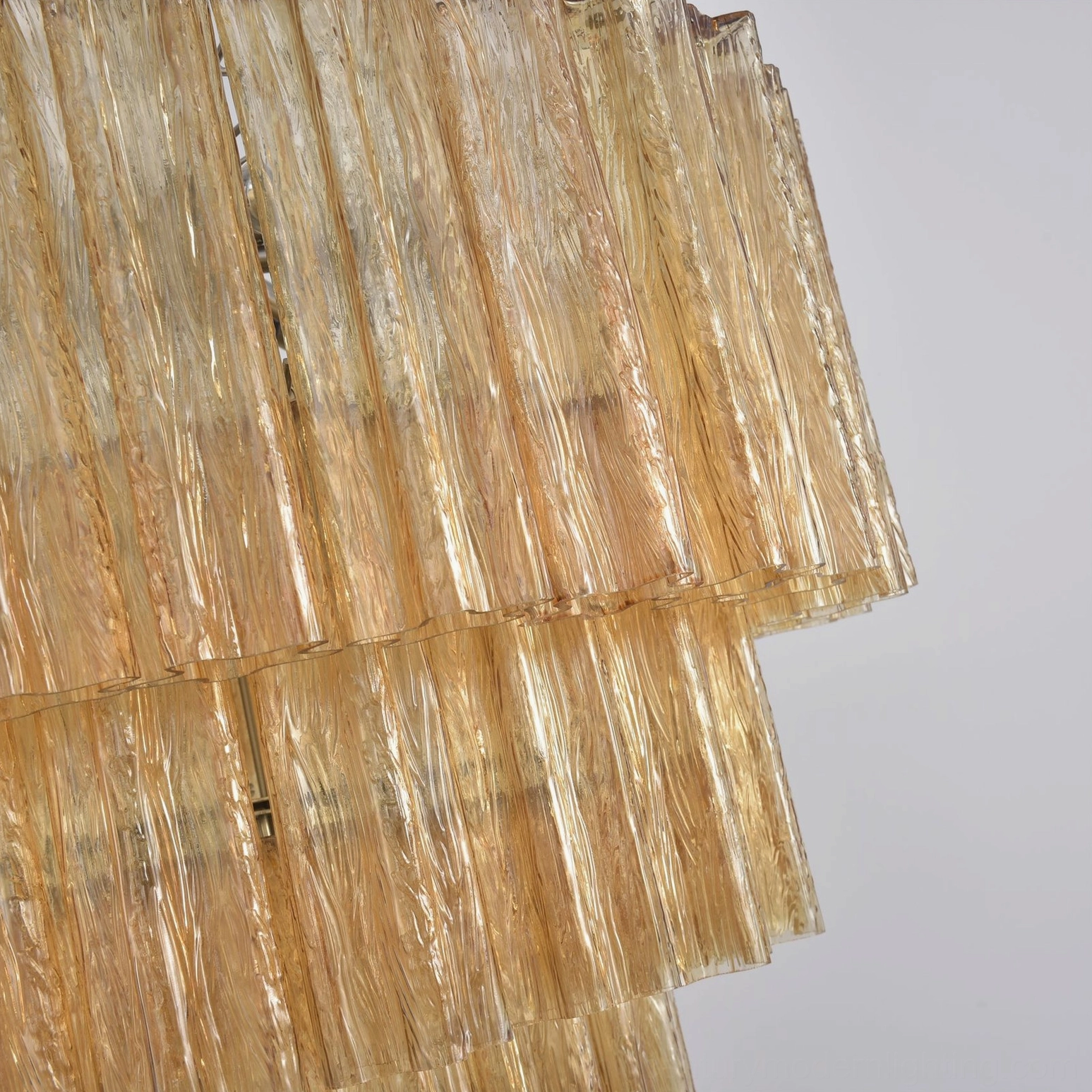 Close-up amber fluted glass tube panels textured layered chandelier detail