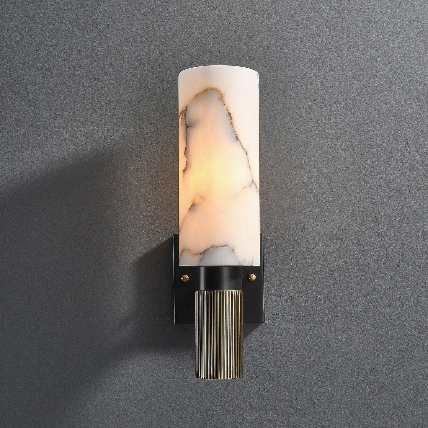 Mid-century modern alabaster wall sconce creating ambient light on grey wall, eye-level installation view