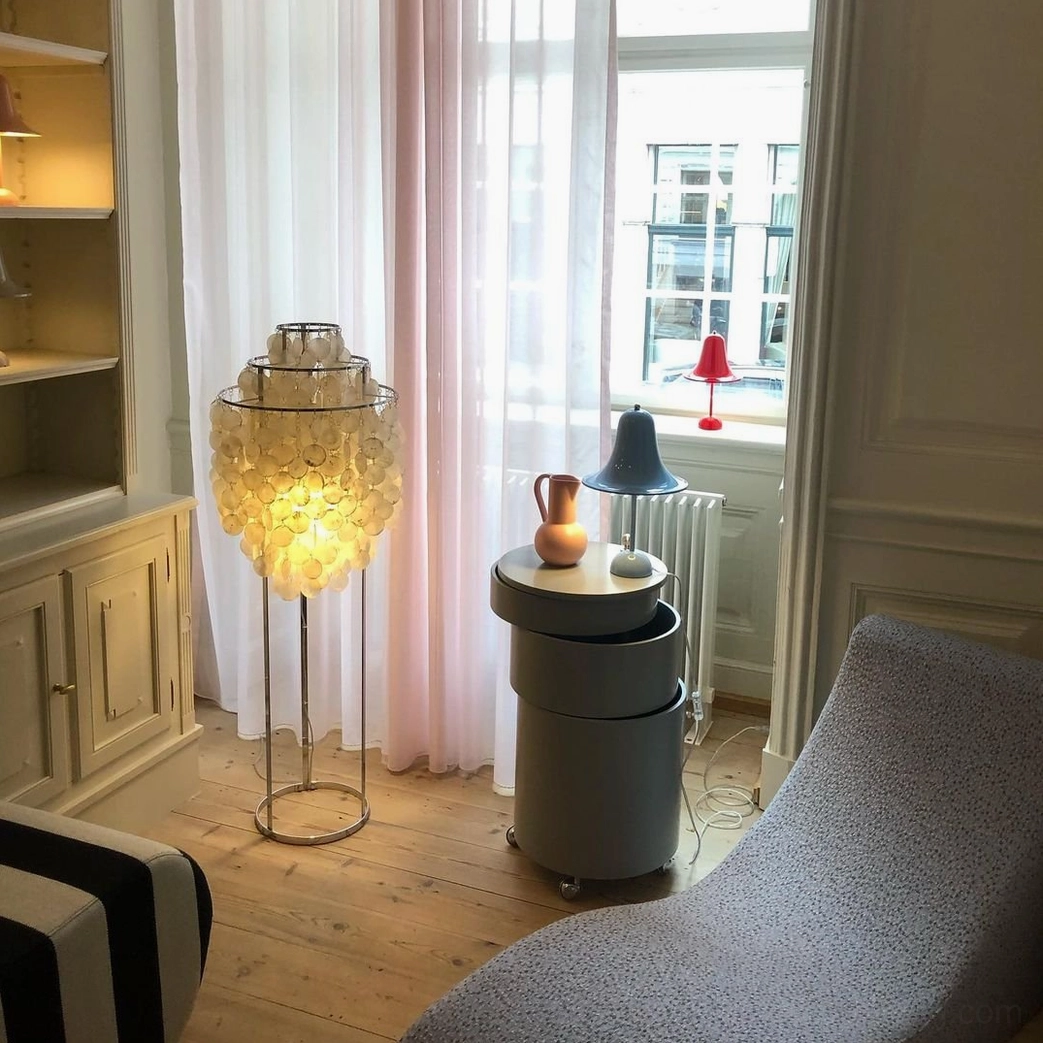 Cozy shell floor lamp with warm amber-toned capiz shells and compact tiered design in residential corner