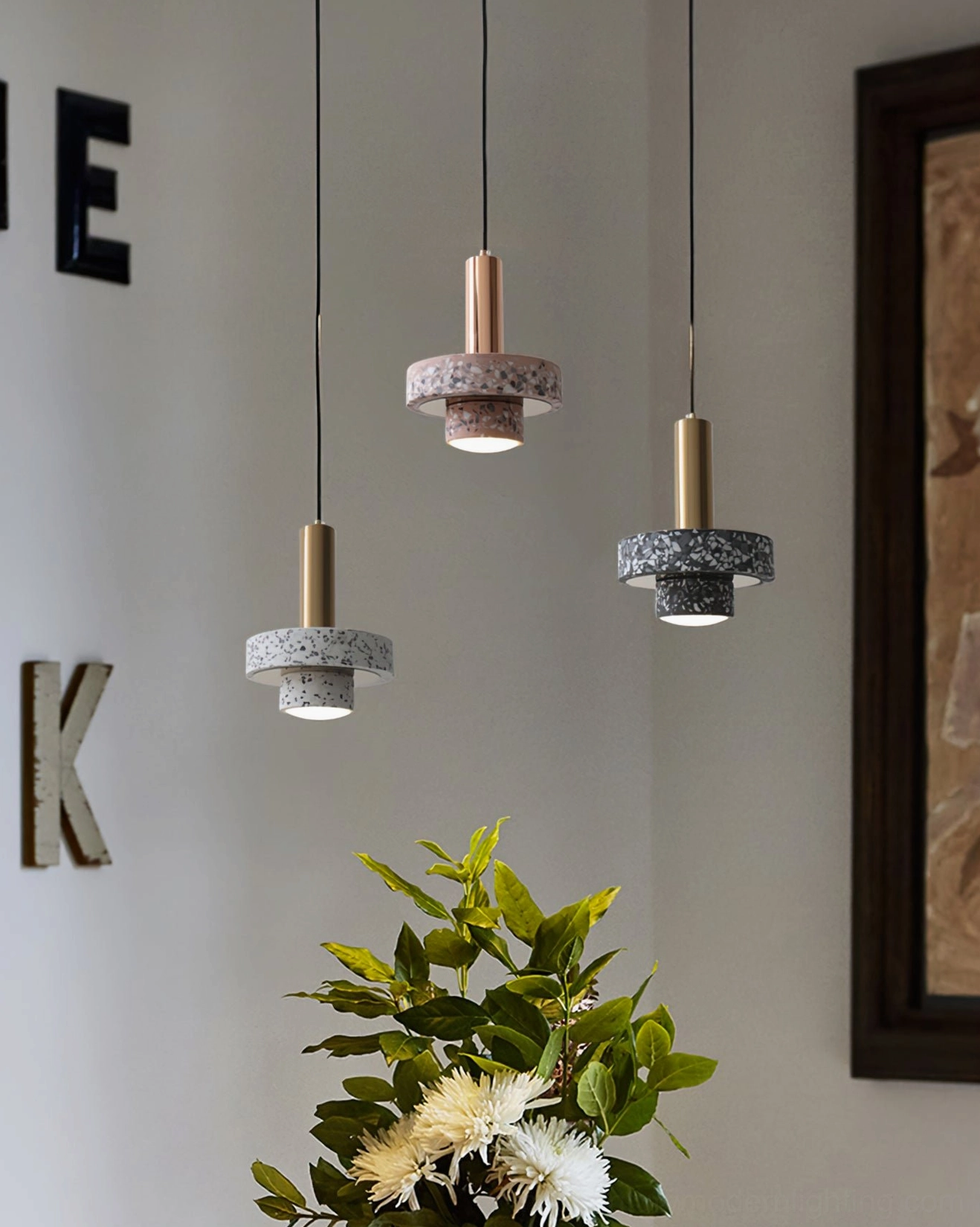 Mixed color terrazzo pendant lamps with brass metal rods in simple living room setting