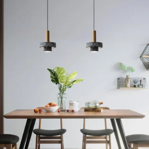 Multiple terrazzo pendant lamps installed in Nordic dining room with dark terrazzo shades and brass fixtures