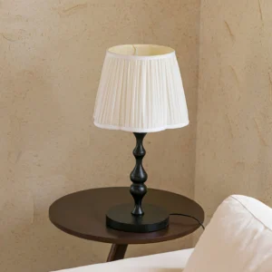 Mid-century modern Ambrosia table lamp positioned on dark side table in contemporary living room with textured plaster wall