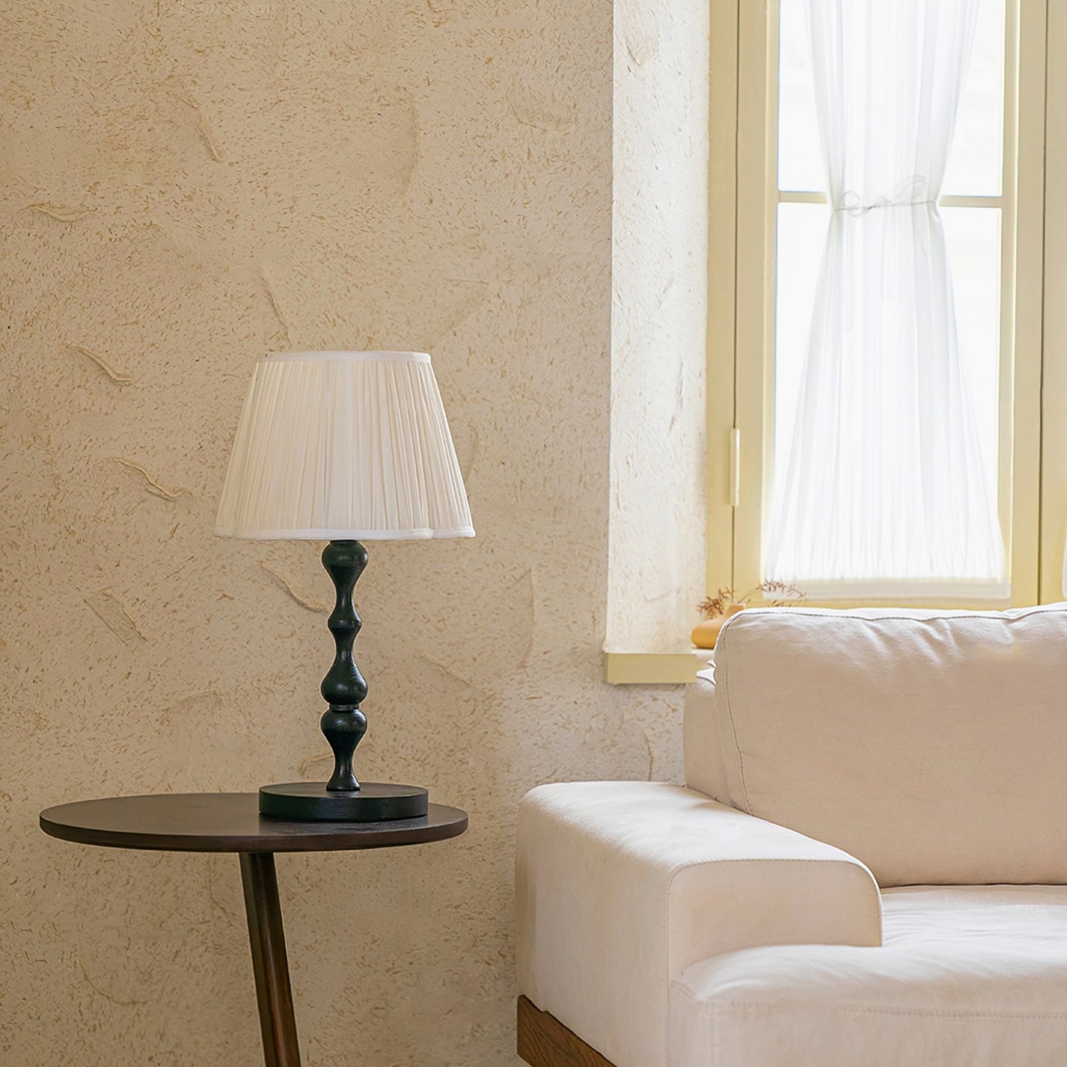 Modern fabric table lamp positioned near window with sheer curtains, minimalist living room side table styling