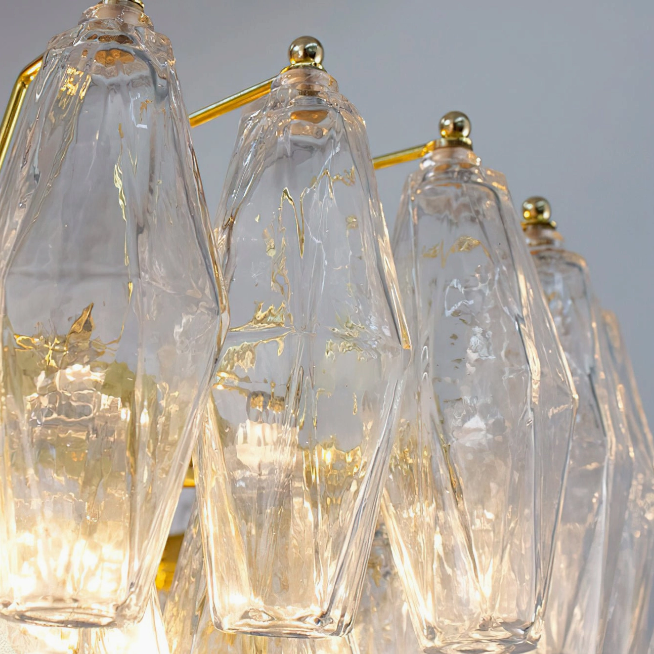 Clear and gold Ametista glass chandelier front view highlighting transparent glass prisms with sculptural geometric form