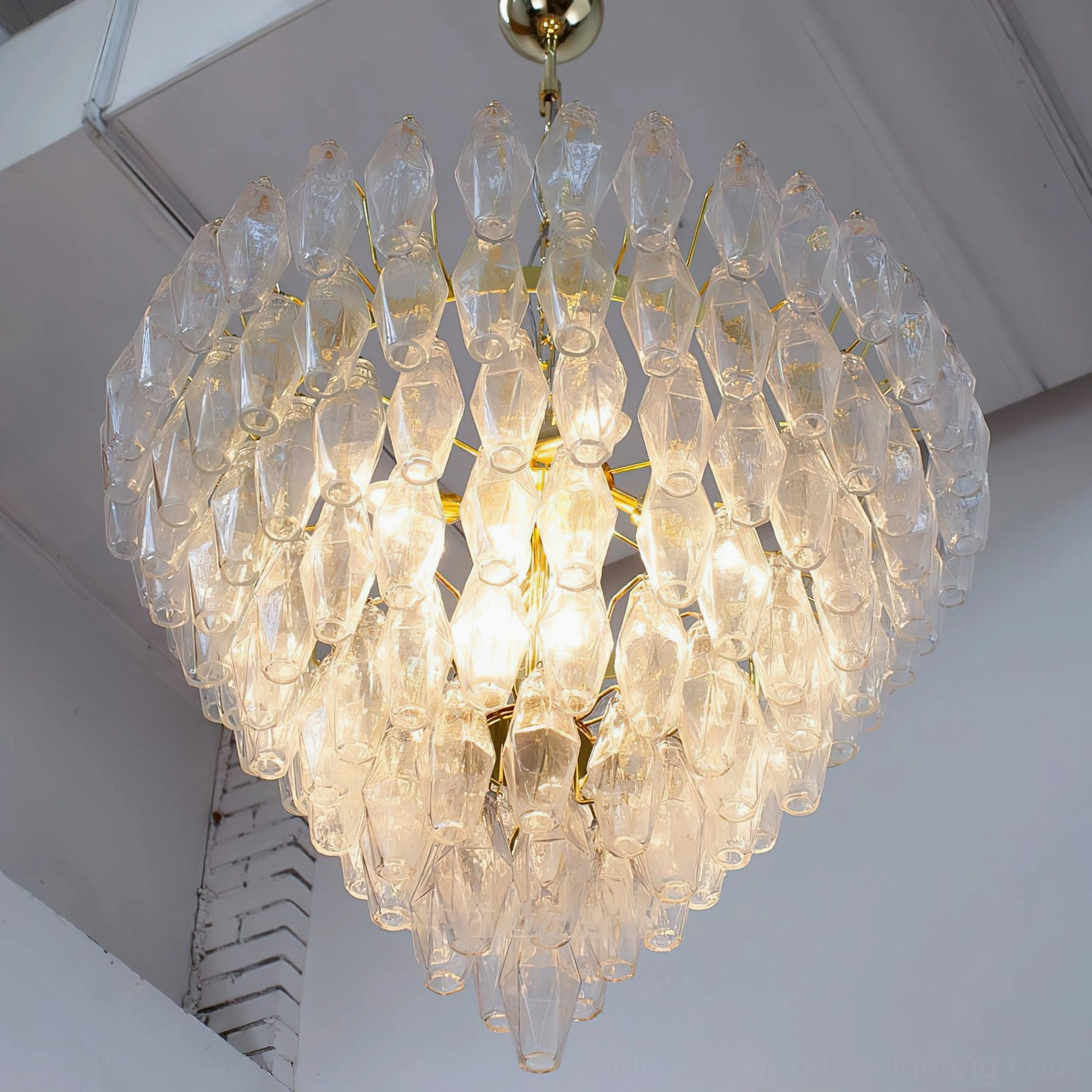 Ametista geometric chandelier detail view showing individual polyhedral glass prism tiles and brass metal framework construction