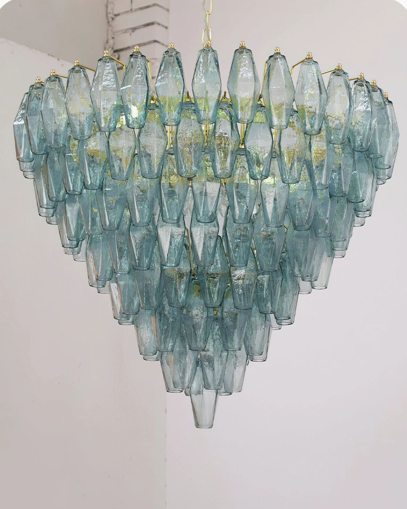 Close-up front view of teal Ametista glass chandelier showing layered prismatic glass droplets and gold metal accents on white background