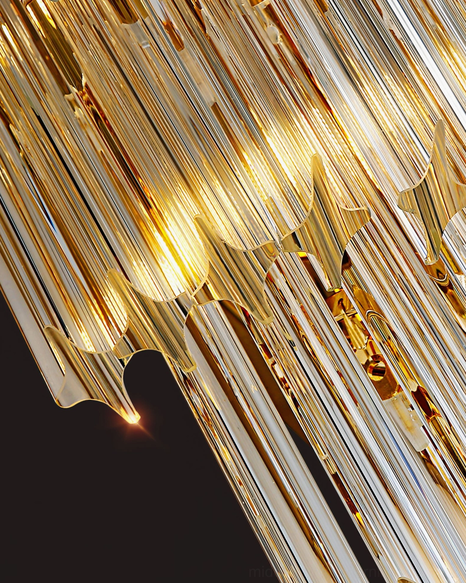Overhead view of stacked light-reflecting crystal rods with gold metal accents on reflective background