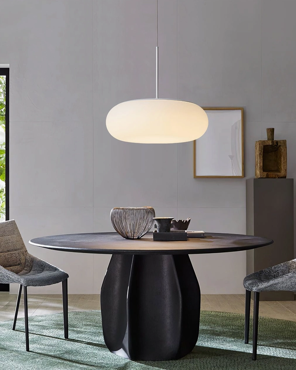 Amor white pendant lamp above modern dark round dining table, warm light diffusion over contemporary dining space