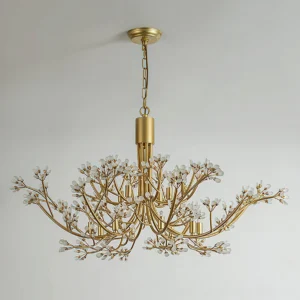 Anais crystal chandelier installed in modern minimalist white interior, showcasing warm brass patina and light refraction through crystals