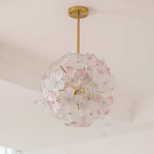 Anan Floral Chandelier illuminated in minimalist living room with cream interior, showing soft pink glass flowers and gold metal suspension