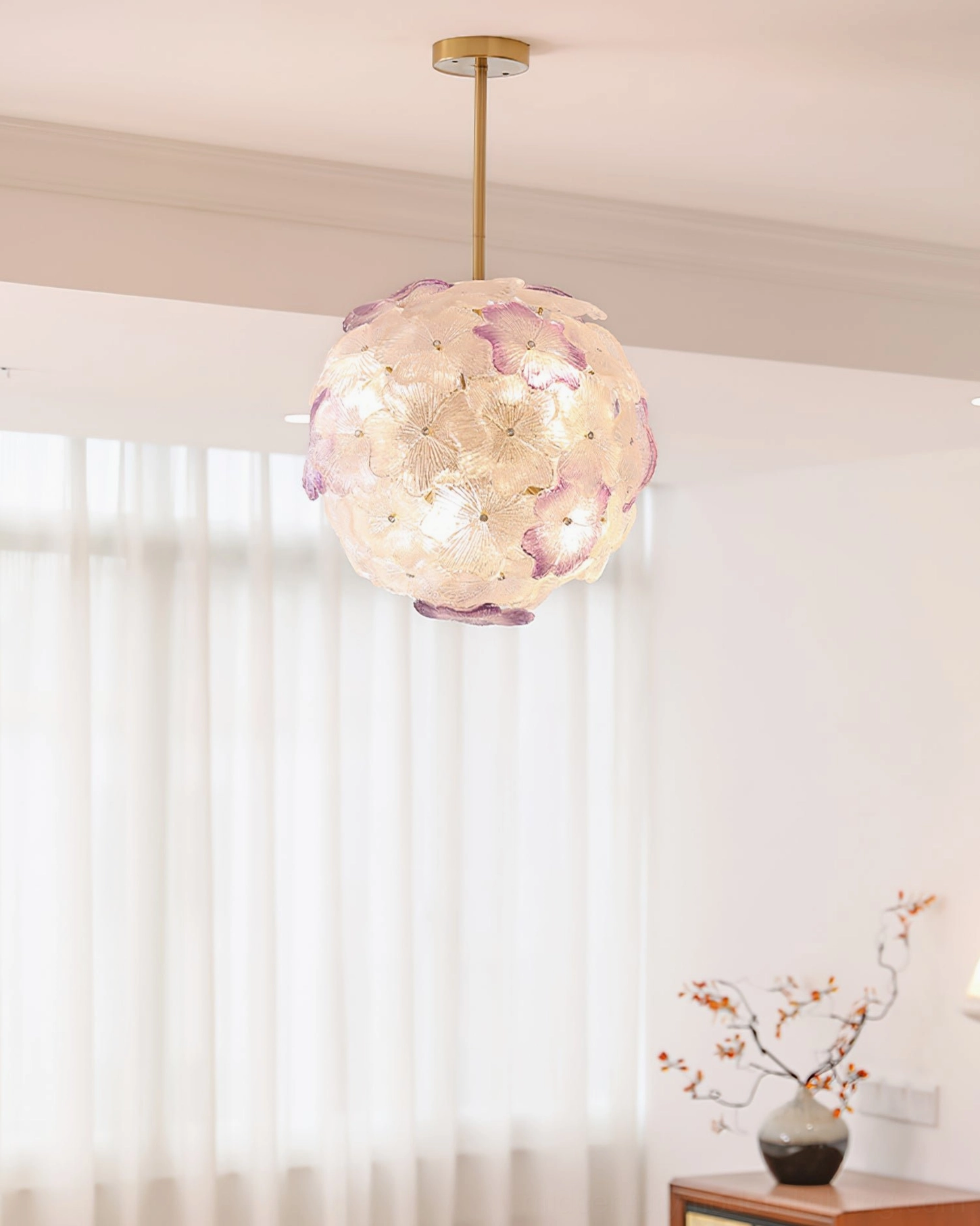 Anan Floral Chandelier in soft pink three-quarter view, lit warm white light, elegant white curtains and living room decor