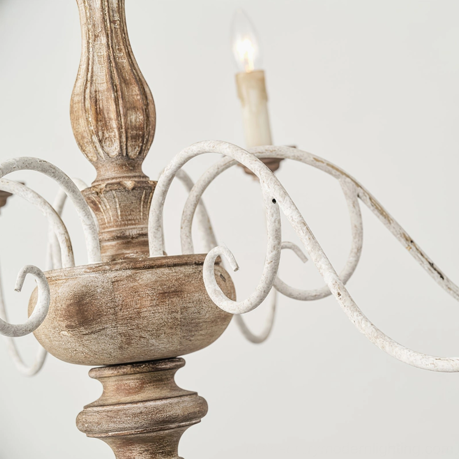 Anchor chandelier partial detail showing whitewashed light wood column and off-white curved iron arms