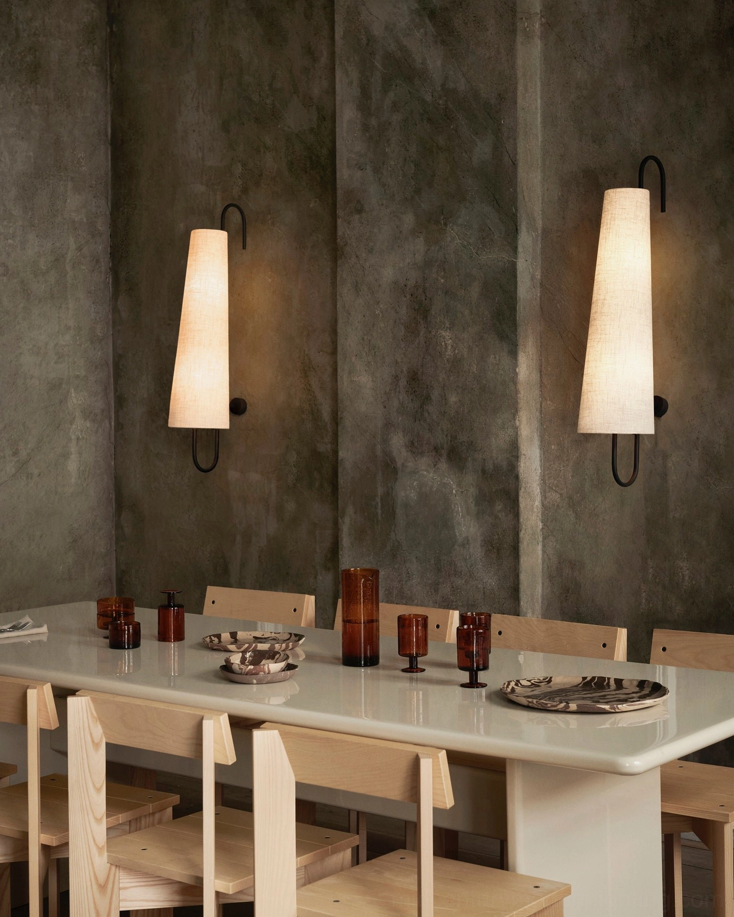 Twin Ancora wall lamps symmetrically installed in rustic dining area above wooden furniture, showcasing paired installation design
