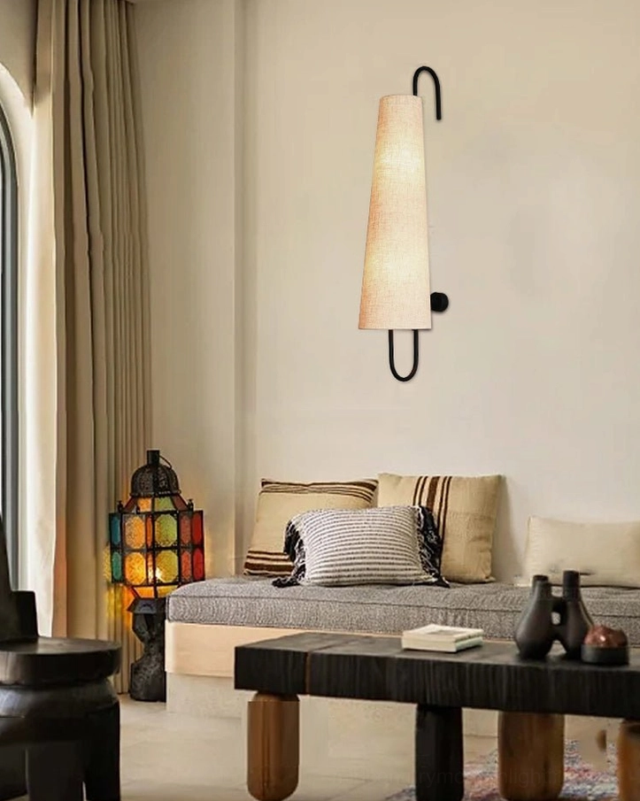 Ancora wall lamp in wabi-sabi living room setting with sofa, throw pillows, coffee table and vintage home accessories