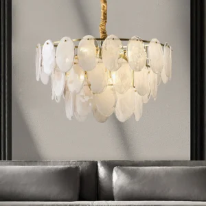 Modern glass tiered chandelier side view installed above gray sofa living room mid-century lighting