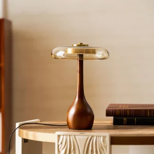 Andi mid-century table lamp on wooden side table with stacked books in warm home interior