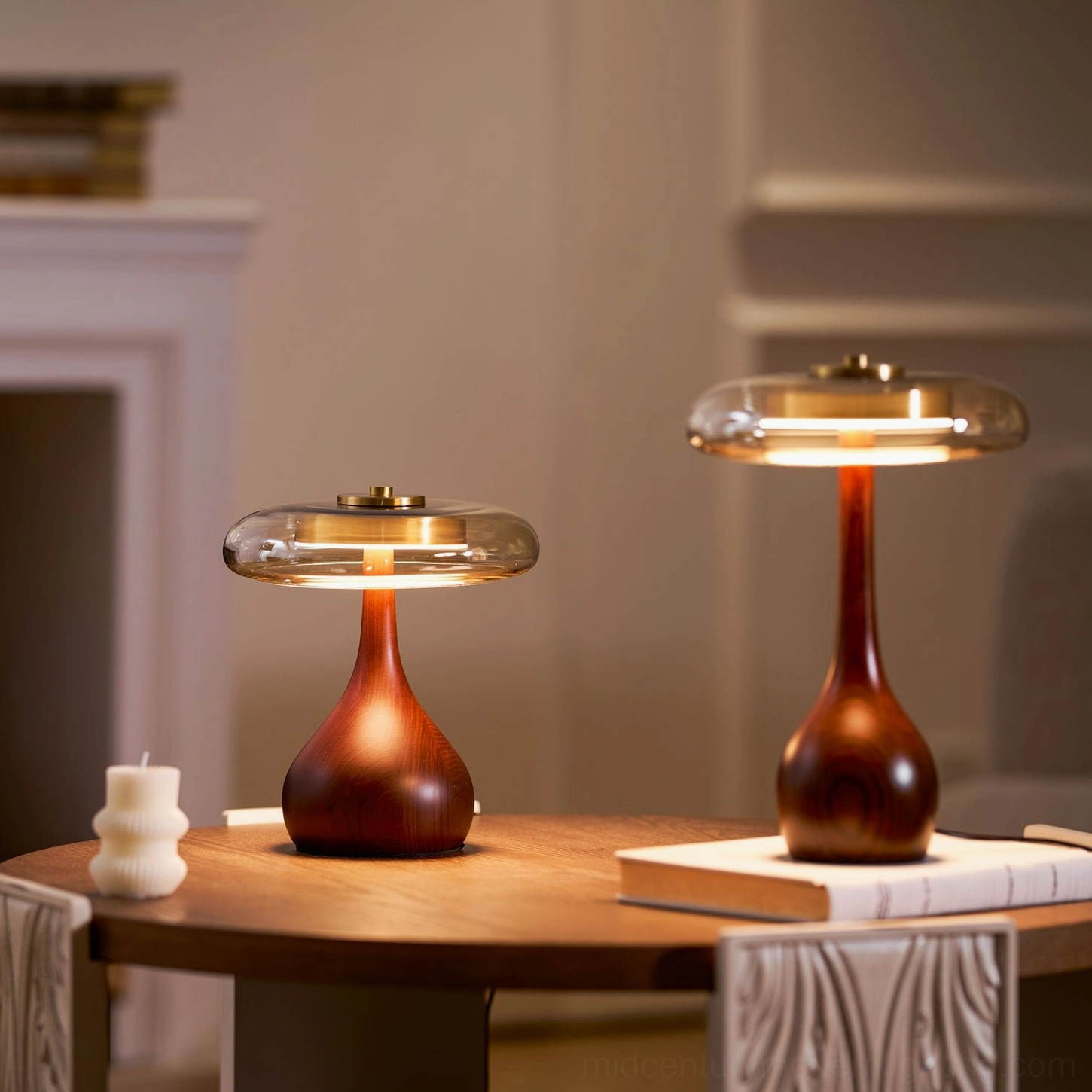 Pair of matching Andi Glass Table Lamps on dining table with fireplace and lit illumination