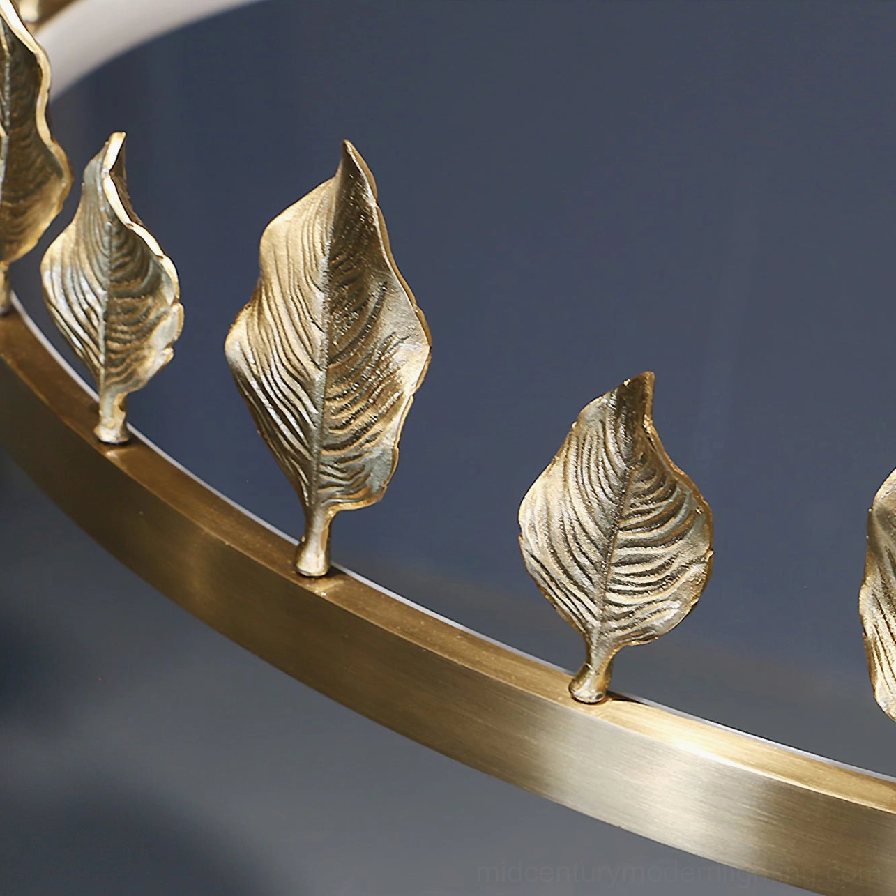 Macro detail shot of textured brass leaf ornaments and polished brass ring on Anello pendant