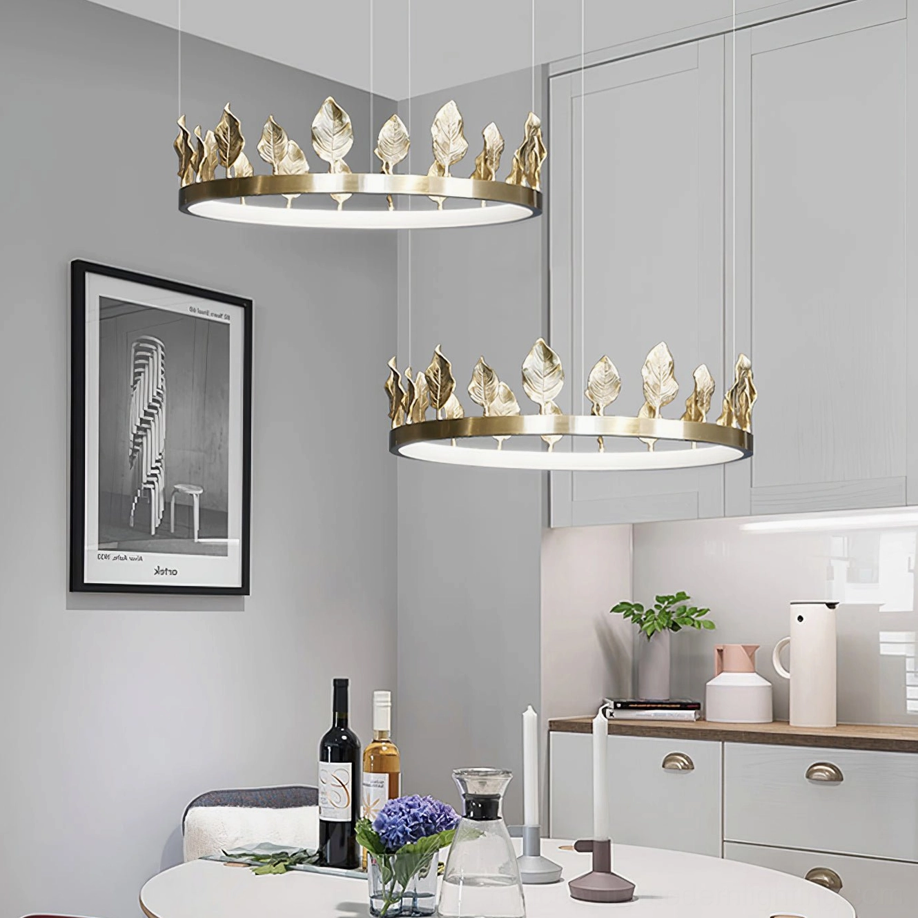 Multiple Anello brass leaf chandeliers in modern dining and kitchen space with white cabinetry