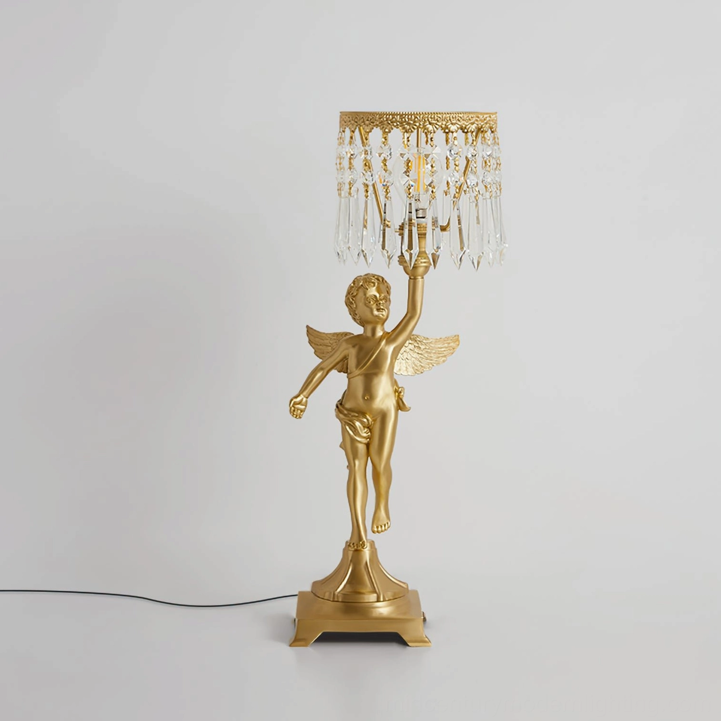 Rear and side profile of brass angel crystal table lamp showing power cord, square metal base, and sculptural base design