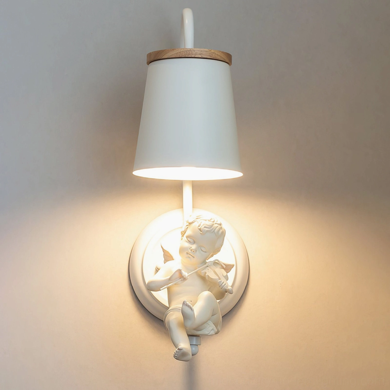 Decorative angel wall lamp with cherub figure and round fabric shade on warm beige home interior wall