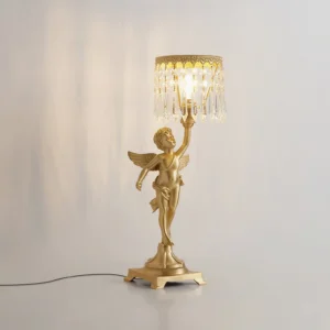 Three-quarter angle view of brass angel crystal lamp illuminated with warm light, highlighting vintage luxury and prismatic crystal details