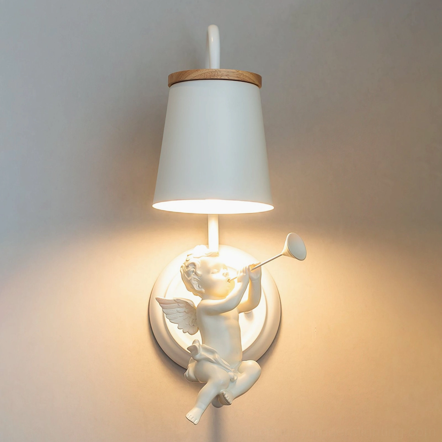 Celestial angel wall light fixture with warm glowing illumination and wood-trimmed fabric shade on grey interior wall