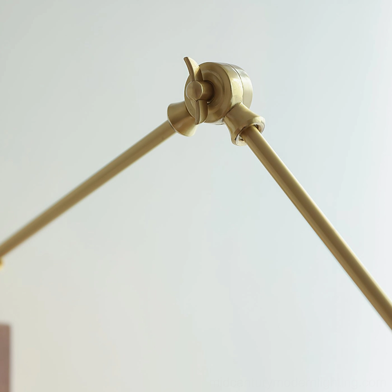 Angeline wall lamp brass knuckle joint detail, close-up of articulating hinge mechanism, polished brass metal hardware