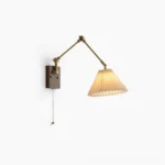 Angeline swing arm wall lamp with brass joints and walnut wooden base, pleated white fabric shade, frontal product view on white background showing full design