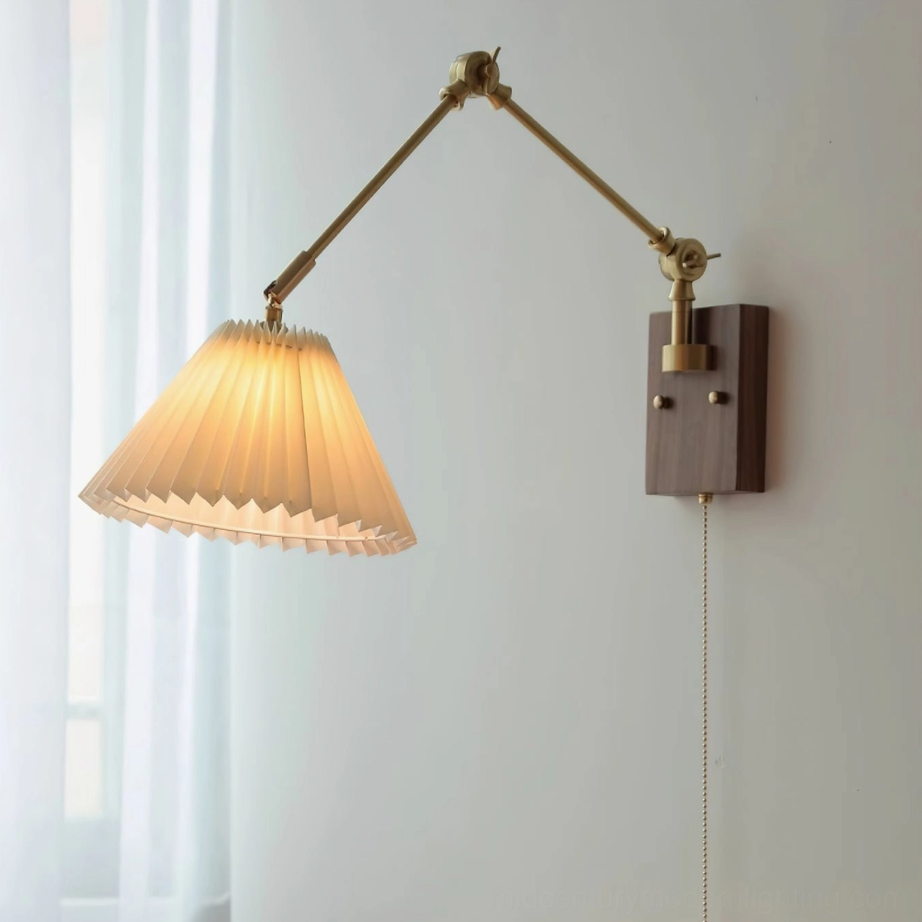 Angeline swing arm wall lamp lit and mounted on light wall, frontal side view displaying warm yellow light through pleated shade and wall-mounting position