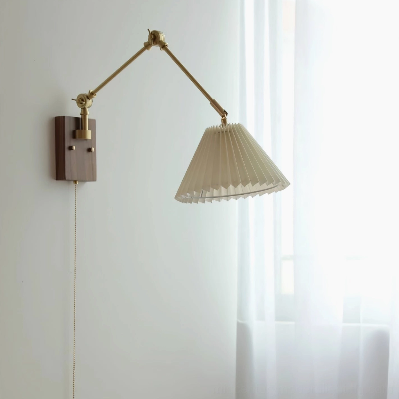 Angeline swing arm wall lamp unlit side profile view showing off-white pleated fabric shade and brass metal components against interior wall with sheer curtains