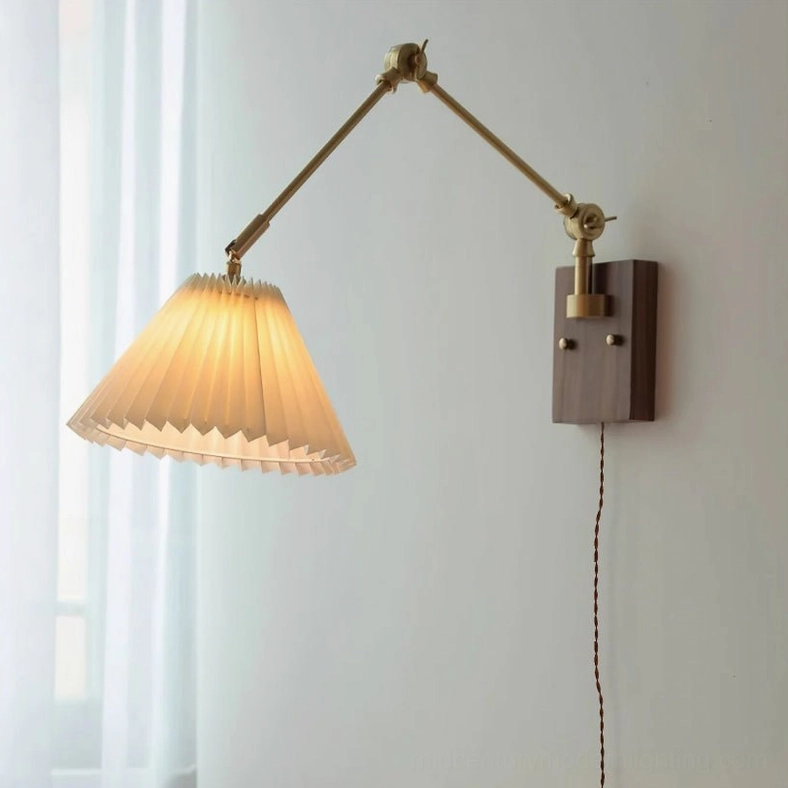 Angeline swing arm wall lamp side view with illuminated pleated shade, dual articulating arms, brass joints, walnut mounting plate