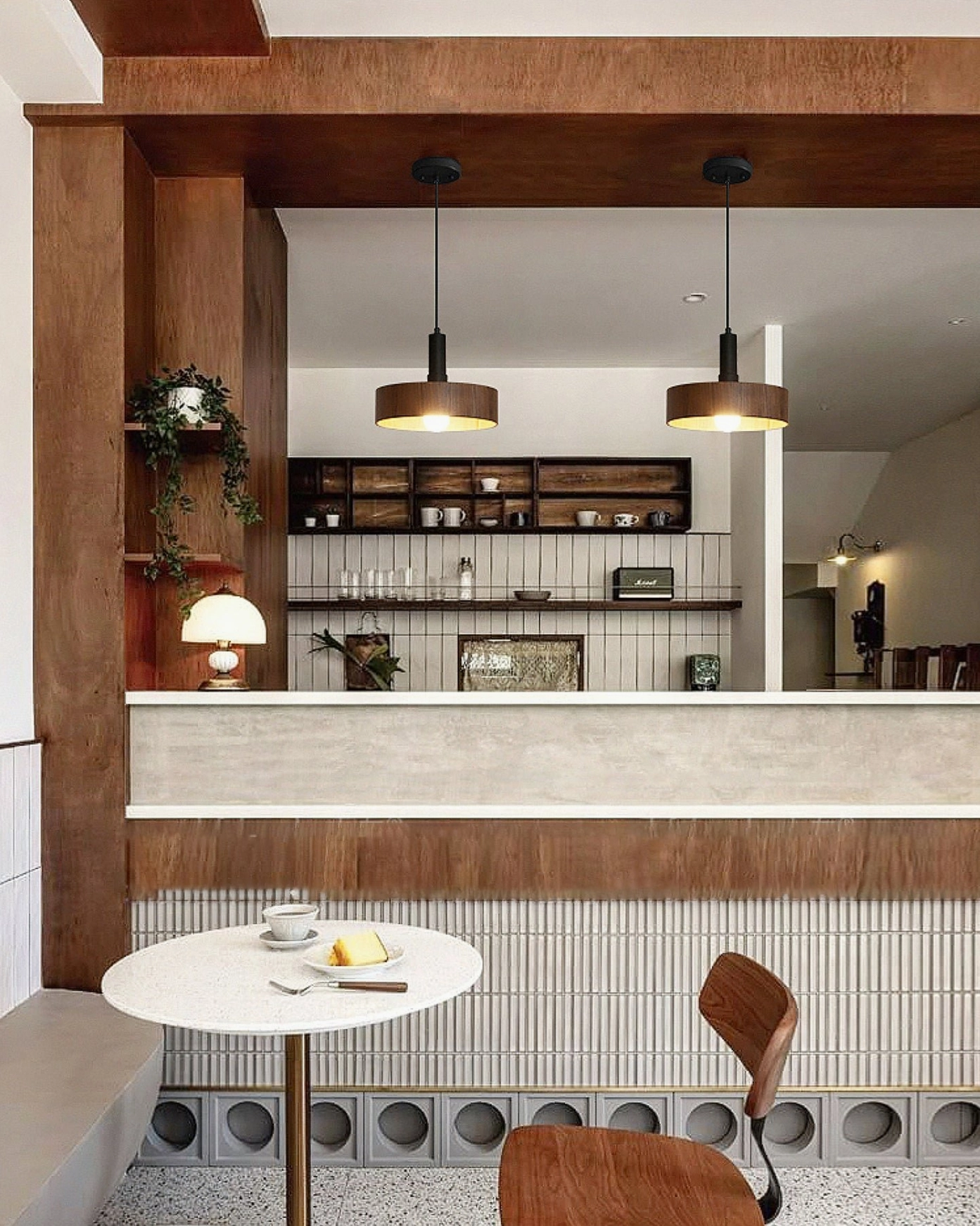 Matching pair of Angilia walnut wood pendant lights in cafe service counter area, warm neutral interior design with cohesive lighting
