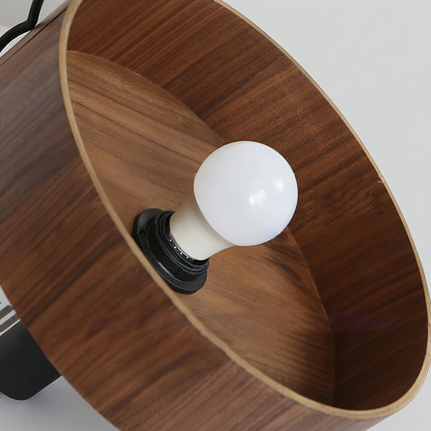 Angilia pendant light fixture suspended in modern interior space, showcasing warm wood tones and focused downward illumination