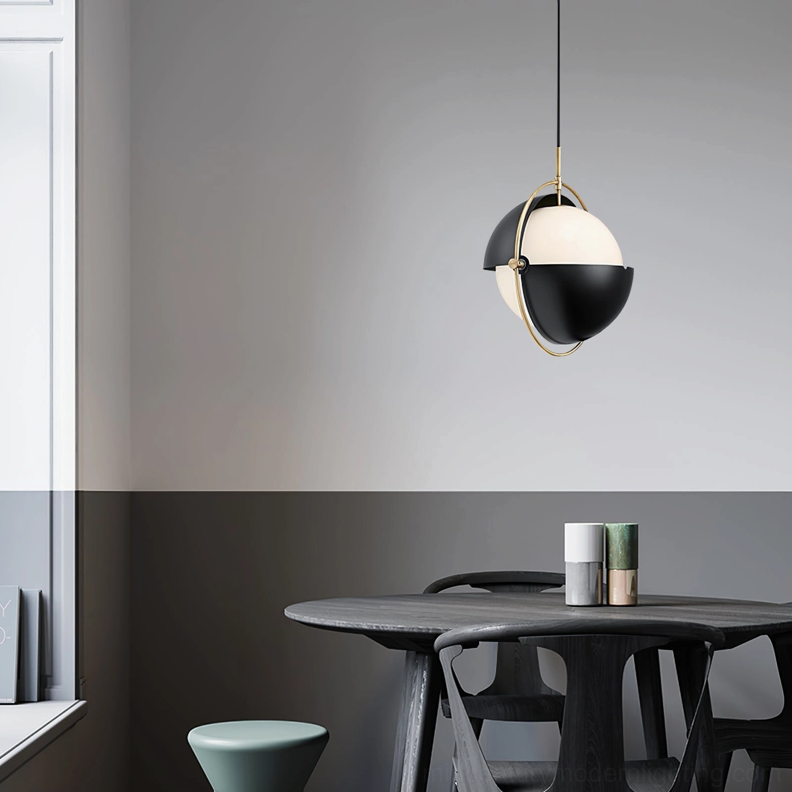 Black-gold Anix sculptural pendant lamp illuminating modern dining area with geometric light diffusion