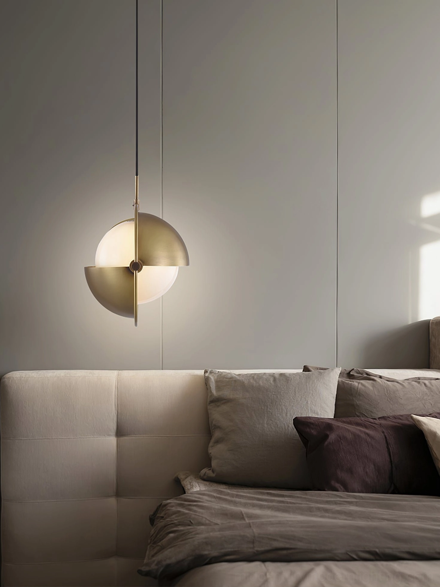 Anix brass pendant with frosted glass shade and adjustable hemisphere in sofa lounge relaxation area