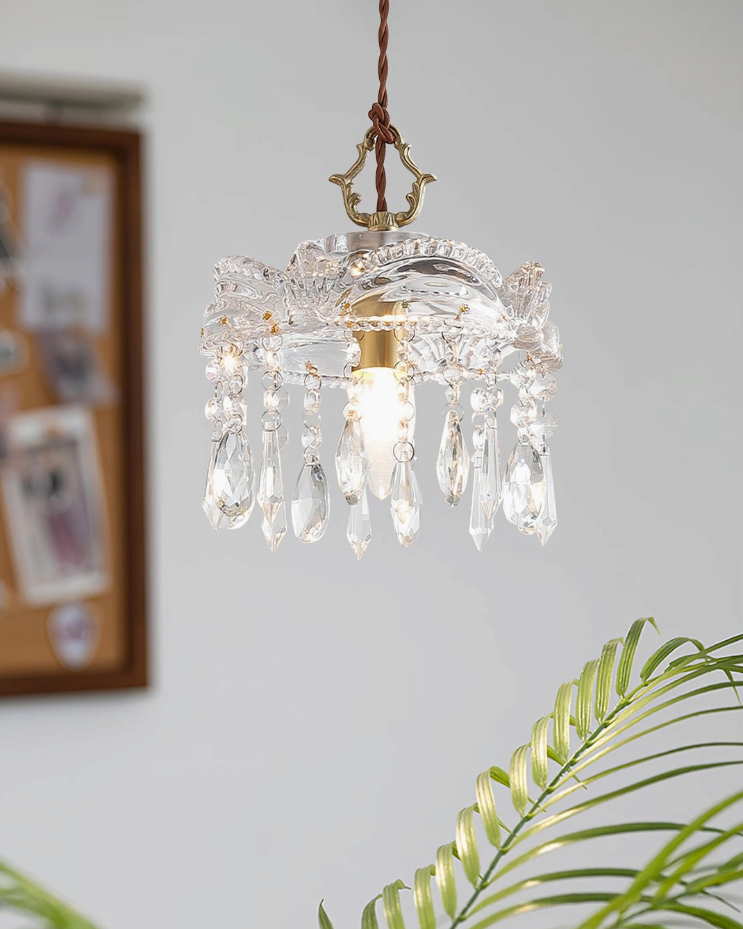 French vintage crystal pendant with teardrop accents and brass finish, hanging in home interior with decor