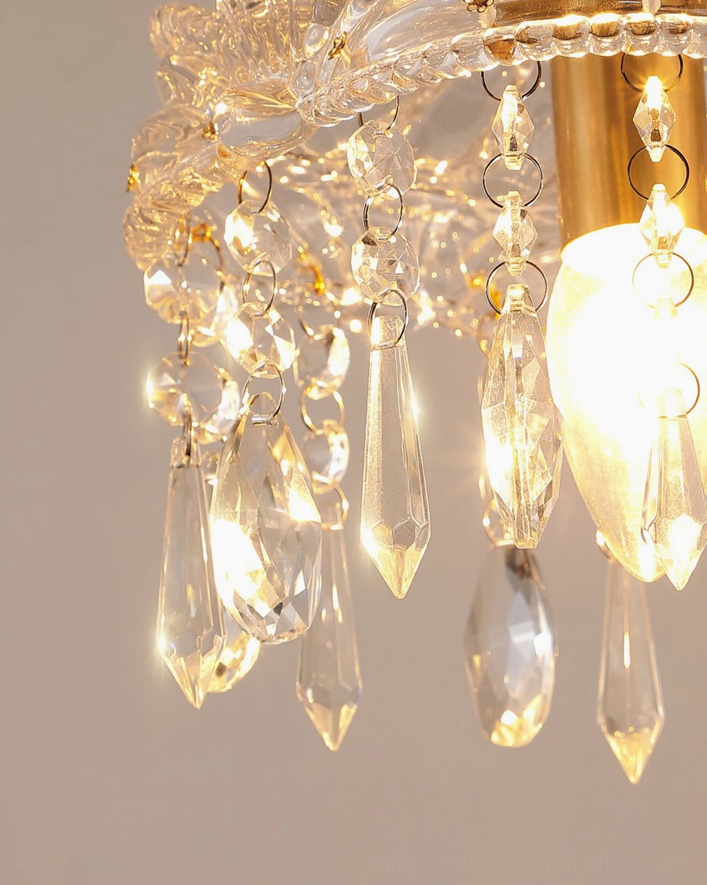 Lit Antigua crystal pendant with warm glowing bulb, gold brass finish and teardrop crystal pendants
