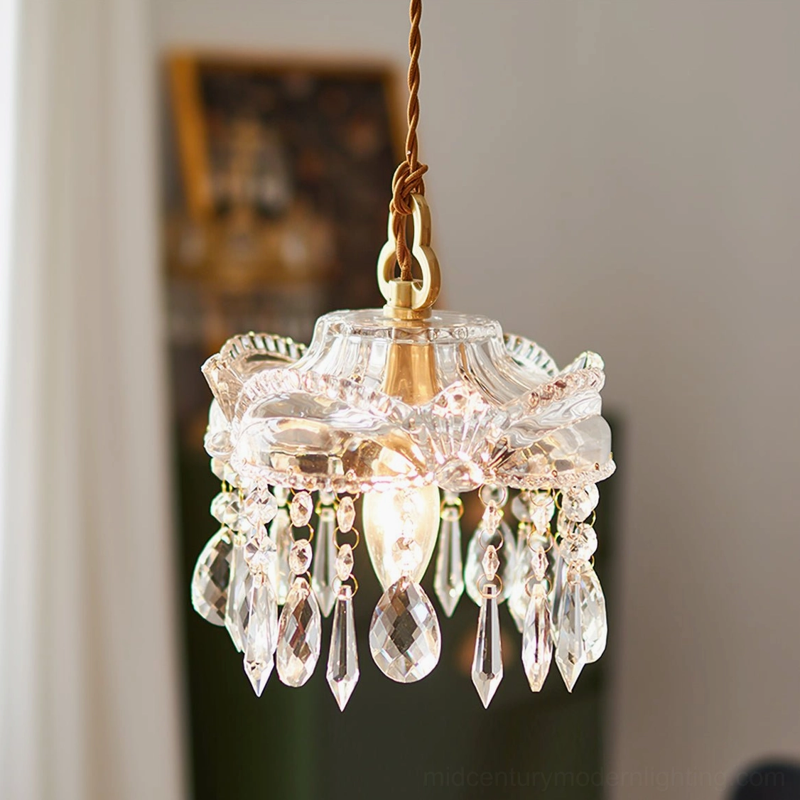 Classic romantic crystal pendant with teardrop trim and brass hanging hardware, low frontal indoor view