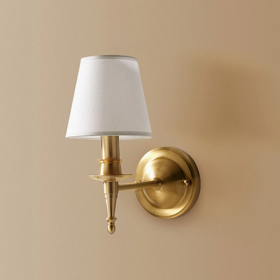 Brass and linen wall sconce showing warm candlelit ambiance through natural textile diffuser