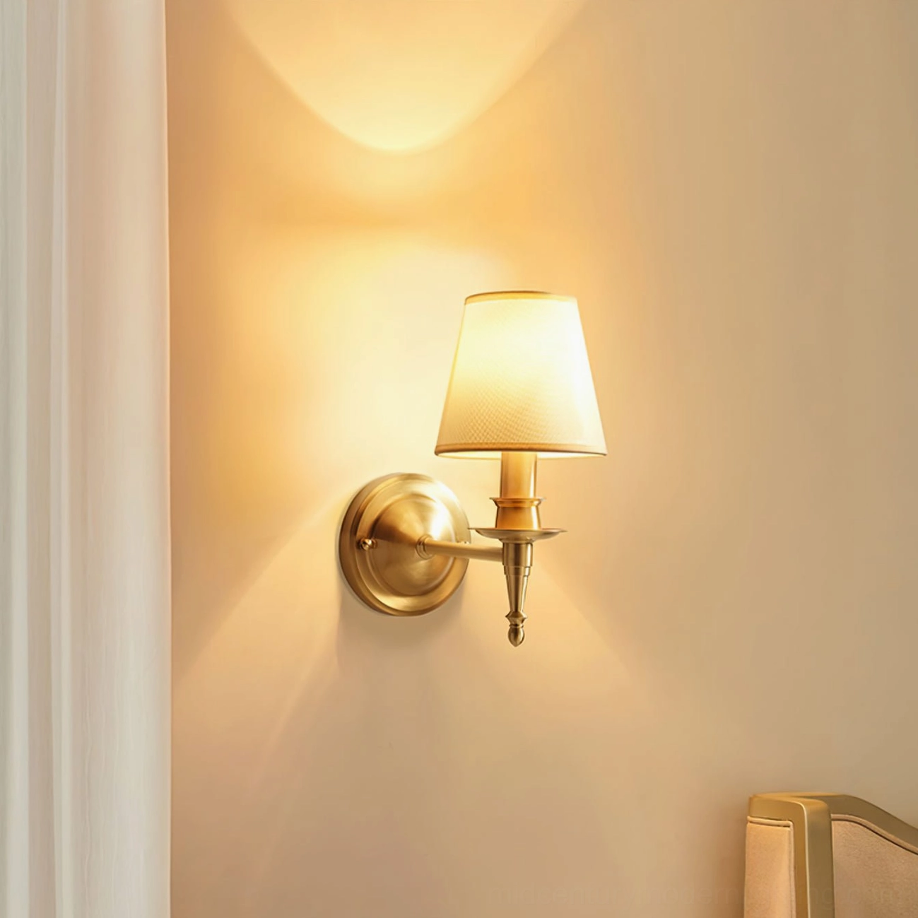 Front close-up of antique brass wall sconce showing warm patinated finish and linen shade texture