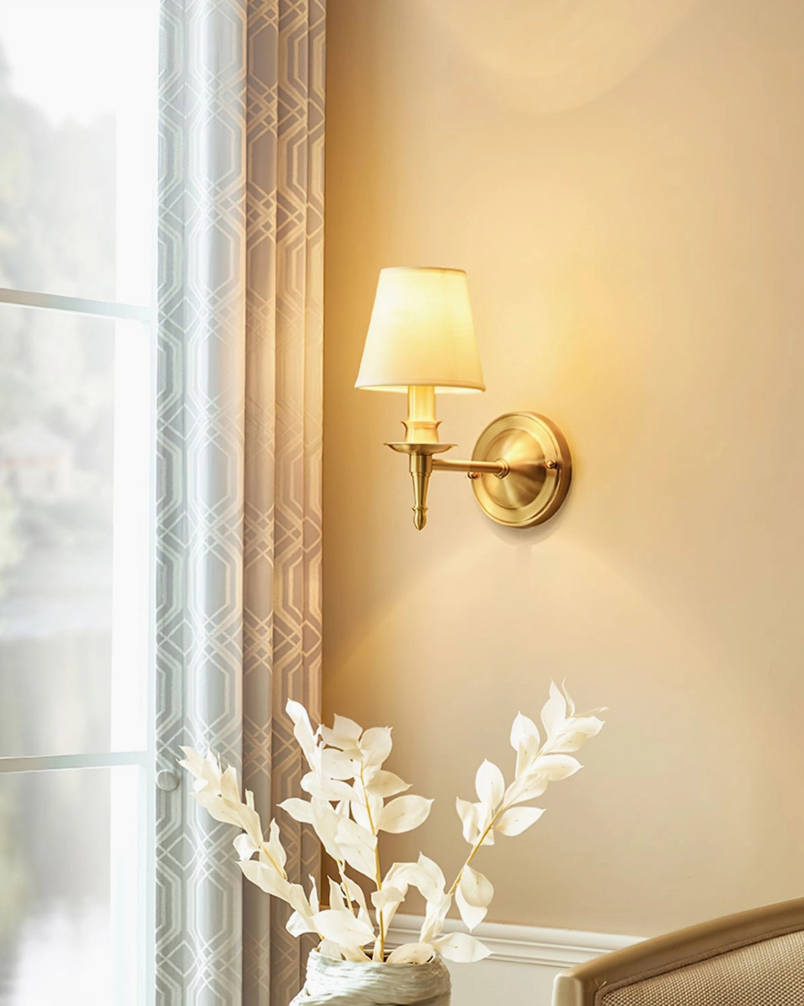 Antique brass wall sconce in home interior with floral decor accent