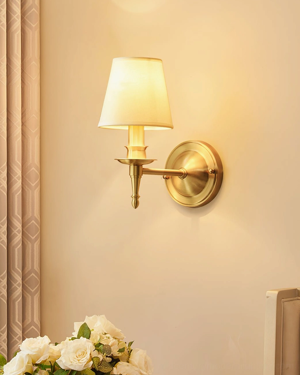 Detailed frontal view of antique brass wall sconce showing metal arm structure and linen shade weave