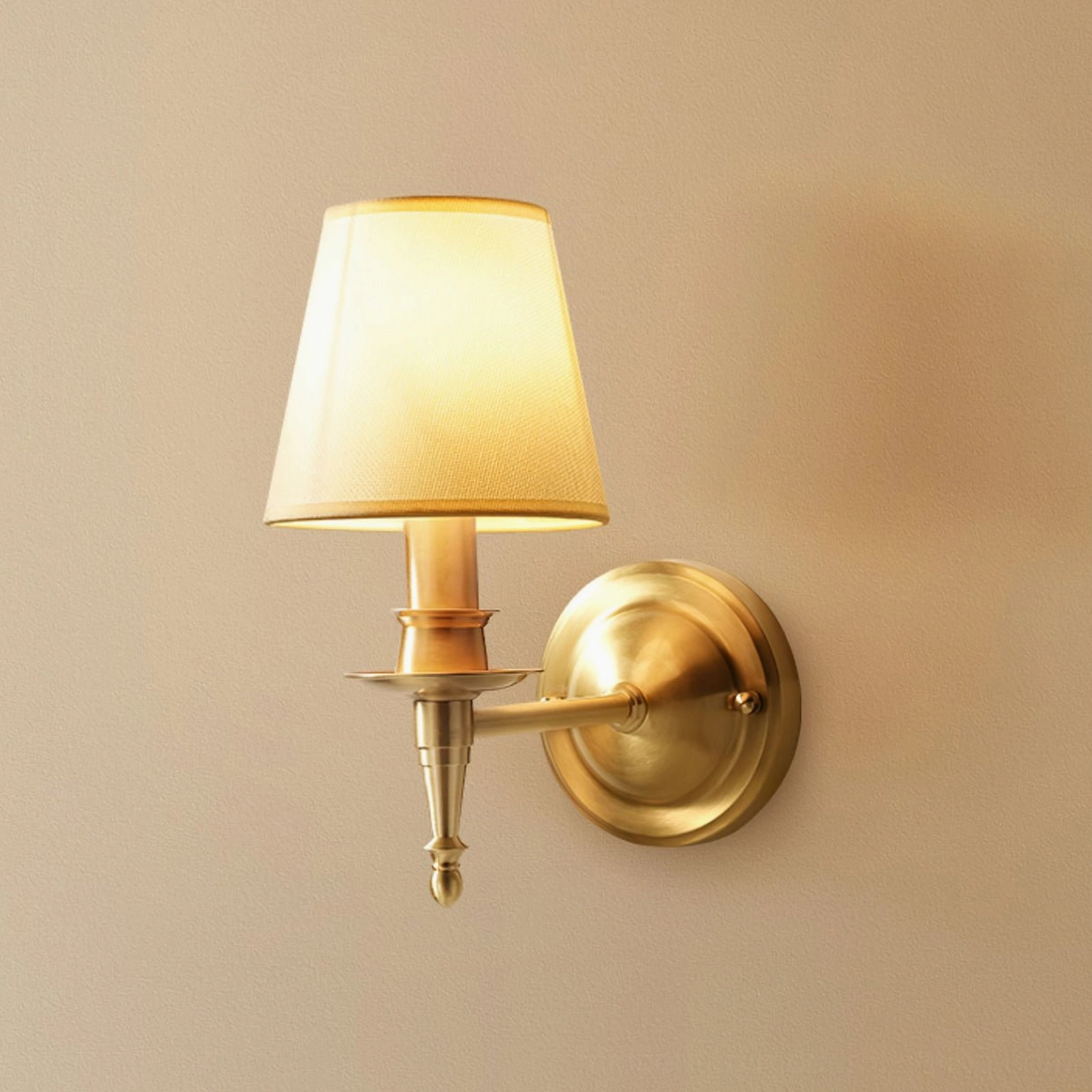 Close-up side view of antique brass wall sconce highlighting brass arm articulation and linen diffuser detail